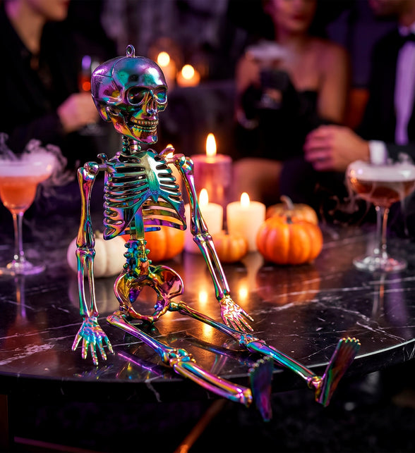 Metallic regenboog skelet op tafel tussen kaarsen en pompoenen op een Halloweenfeest