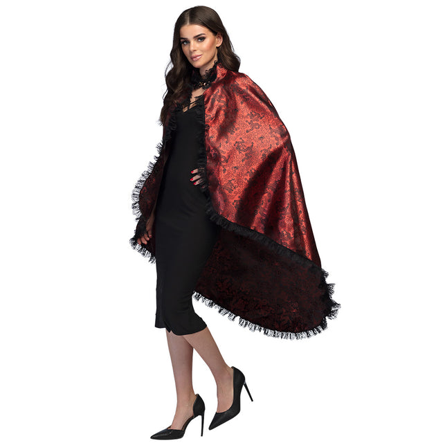 Cape Blood lady in rood met zwart barokdessin en kanten ruche, gedragen over een zwarte jurk