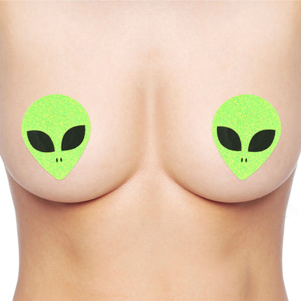 2 Tepelstickers alien UV in neongroen met glitter en zwarte alienogen, op de huid geplakt