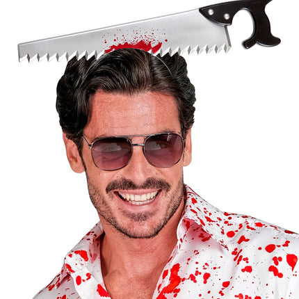 Man draagt bloederige zaag in hoofd boven bloedspatshirt op Halloweenfeest