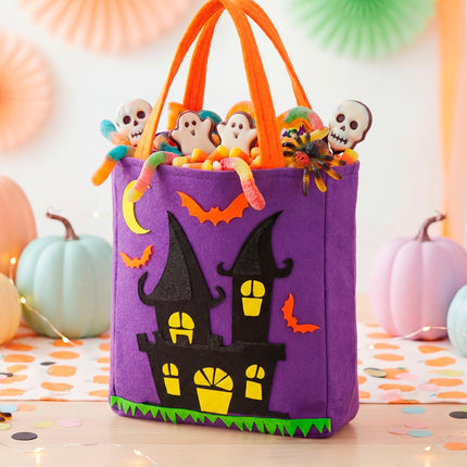 Spookhuis snoeptas gevuld met snoep tussen pompoenen op een Halloweentafel