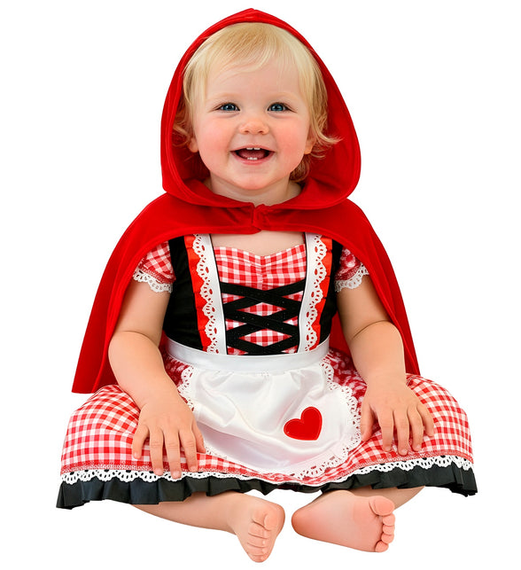 Baby in rode capelet jurk met capuchon, geruit rokje en wit schortje met rood hart