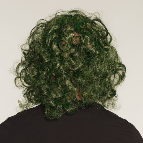 Achterkant van het latex hoofdmasker De Schurk met volle groene krullen over het achterhoofd