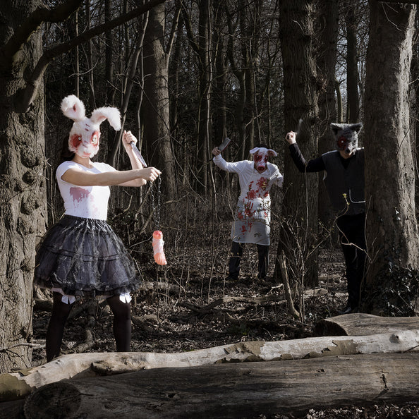 Bebloed wit schort met voorzak in een groepslook met dierenmaskers op een halloweenfeest in het bos