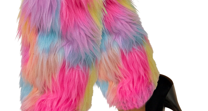 Beenwarmers pluche pastel in roze, geel, blauw en lila, gedragen over de kuiten bij zwarte pumps