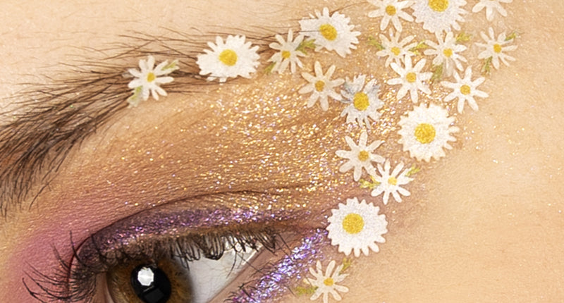 Bloemetjes in wax madeliefjes wit met geel hart geplakt rond het oog voor een flower power-look
