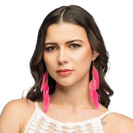 Boho veren oorbellen roze gedragen door een vrouw, drie veren per oor tot op de schouder voor een festival