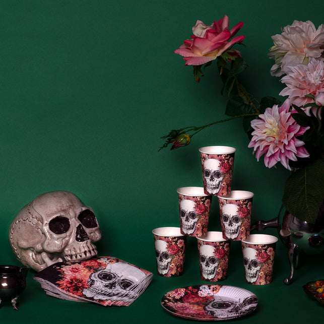 Bordje Day of the Dead op een gedekte halloweentafel naast bekers en servetten met schedelprint