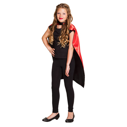 Cape kind Sundown gedragen met zwarte kant naar buiten en rode kraag bij zwarte kinderoutfit
