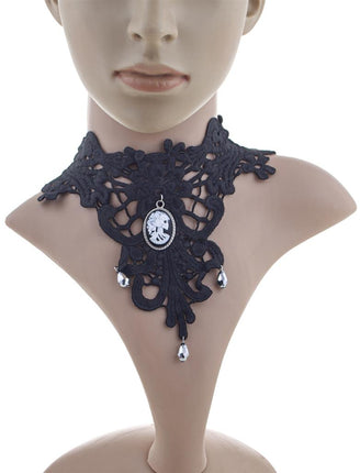 Choker zwart van kant met witte schedelcamee en zilverkleurige druppels, gedragen om de hals