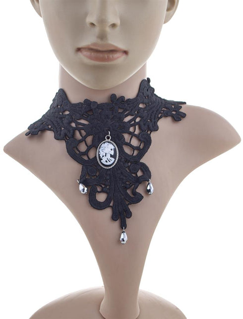 Choker zwart van kant met witte schedelcamee en zilverkleurige druppels, gedragen om de hals
