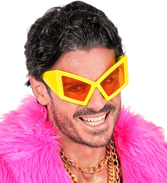 Close-up van de gele oversized feestbril met brede poten en oranje glazen op een man