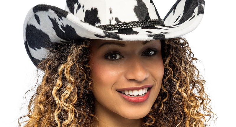 Cowboyhoed Cowchella met zwart-witte koeienprint en gevlochten koord, gedragen door een vrouw voor een festival