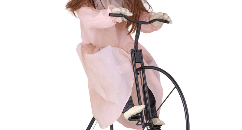 Cycling Cindy animatronic: spookmeisje in roze jurk op zwart hoogwielfietsje voor Halloween