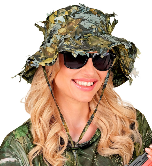 Dame met boonie hoed camouflage en zonnebril, bladeren over de brede rand