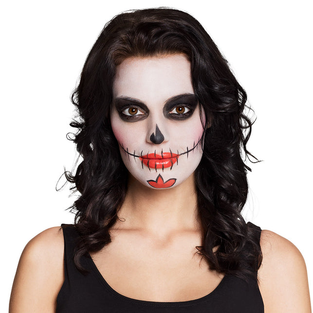 Day of the dead schmink met zwarte oogpartij, rode lippen en stiksellijntjes langs de mond