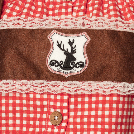 Detail van het hertenembleem op de bruine bib met crème kanten bies en kokosknoop