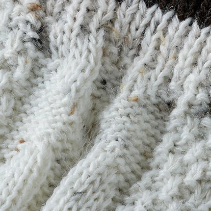 Detail van het kabelbreiwerk in merinowol met donkerbruine boord van de tiroler set