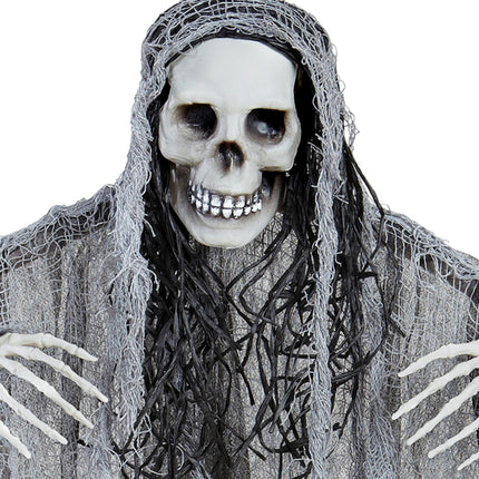 Detail van de schedel met grijnzende tanden en zwarte haarslierten van de grim reaper decoratie