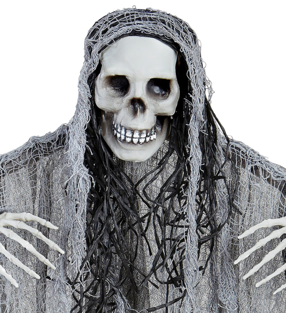 Detail van de schedel met grijnzende tanden en zwarte haarslierten van de grim reaper decoratie