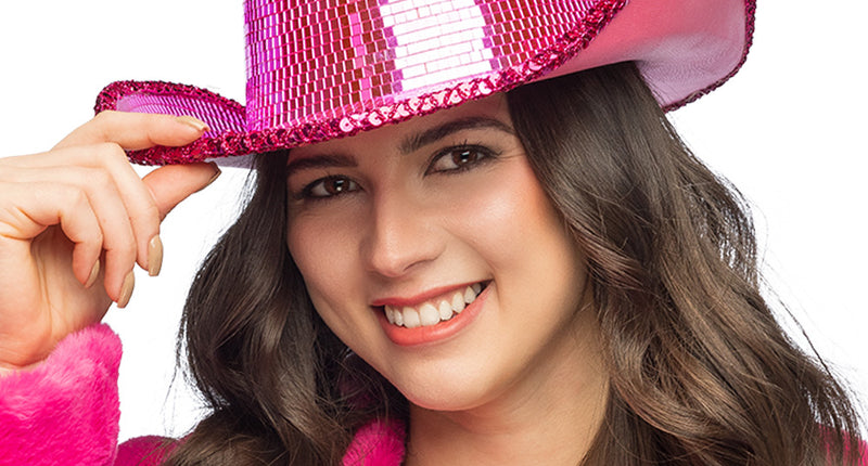 Disco cowboyhoed roze met spiegeltjes en fuchsia paillettenrand, gedragen door een vrouw voor een discofeest