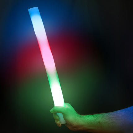 Foam stick led 48 cm in de hand, oplichtend in blauw, rood en groen op een donker feest