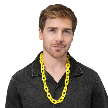 Gele neon schakelketting Vibe gedragen over een zwart overhemd voor een jaren 80-feest