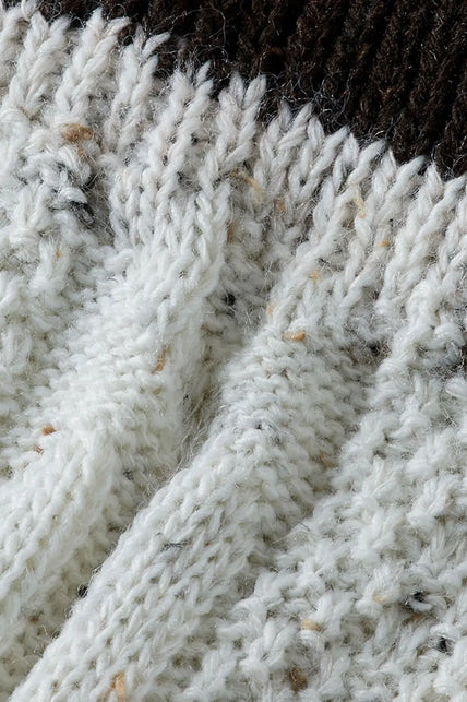 Gespikkeld wit breiwerk met ribstructuur, detail van de tiroler beenwarmer