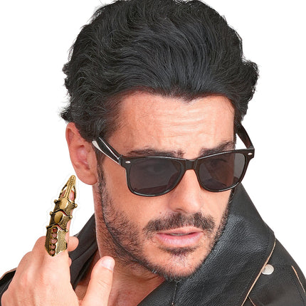 Goudkleurige harnasring aan de vinger van een heer met leren jack, Halloween accessoire