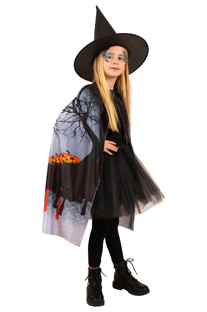 Halloween cape met heksenhoed van zijkant, print met kale boom, pompoenen en bloeddruppels