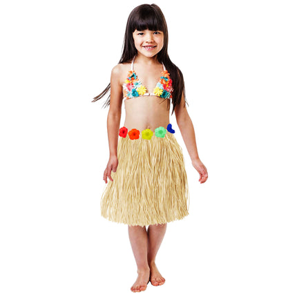 Hawaii rokje van naturel raffia met rij gekleurde bloemen op de taille, gedragen door een meisje