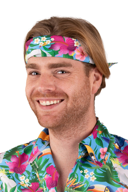 Hawaii zakdoek blauw met roze hibiscus en witte kaketoes, als hoofdband geknoopt op een tropisch feest