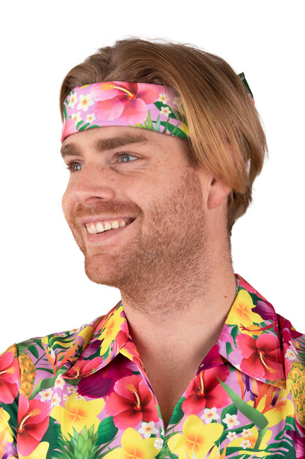 Hawaii zakdoek roze met hibiscusprint als hoofdband gedragen, voor een hawaiifeest