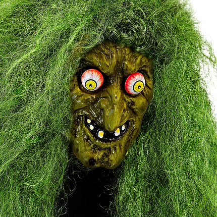 Heksenmasker met wiebelende ogen onder wild groen haar, gerimpeld gezicht met grijns