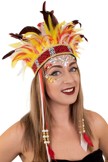 Hoofdtooi El Boscha met gele, rode en witte veren en gouden bies, gedragen door vrouw tijdens carnaval