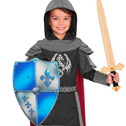 Jongen met houten ridderschild fleur-de-lis bij een ridderkostuum met capuchon, voor een themafeest