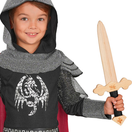 Jongen met houten ridderzwaard in de hand bij een ridderoutfit met kap