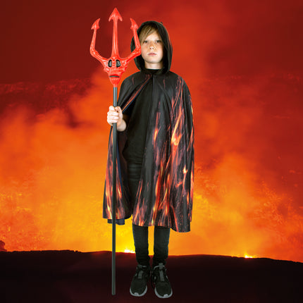 Kind draagt zwarte cape met vlammenprint tegen een lavarode achtergrond, Halloween-look