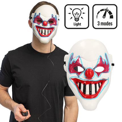 LED masker Clown horror gedragen bij een zwart shirt, met batterijkastje aan snoer in de hand, voor Halloween