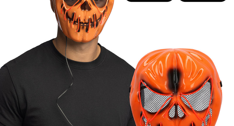 LED masker Pompoen Halloween gedragen bij een zwart shirt, met het batterijkastje aan het snoer in de hand
