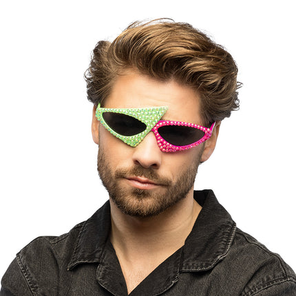 Man draagt de asymmetrische partybril Skunk in neongroen en roze op een neon party