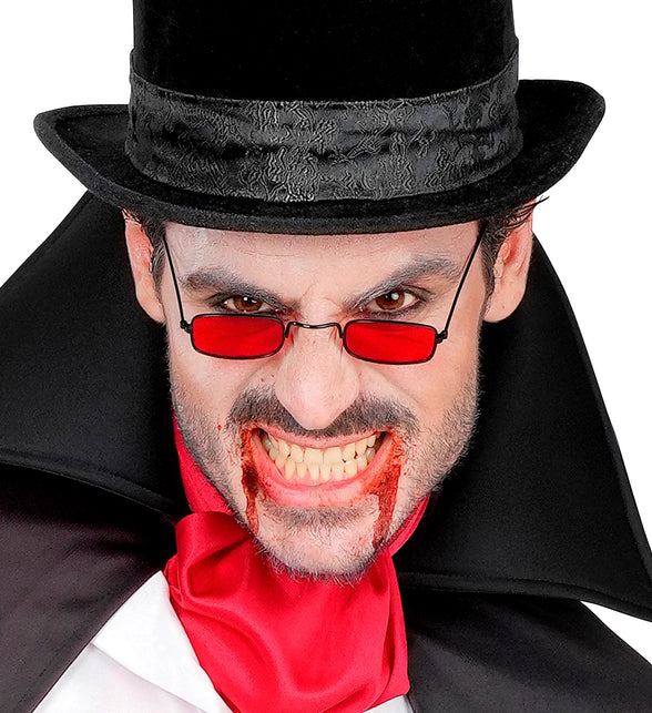 Man met rode vampieren bril, hoge hoed en nepbloed voor een griezelige Halloweenlook