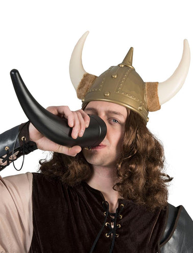 Man met vikinghelm drinkt uit de zwarte drinkbeker hoorn tijdens een vikingfeest