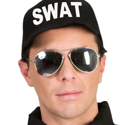 Man met zwarte swat pet en spiegelende pilotenzonnebril tijdens een verkleedfeest