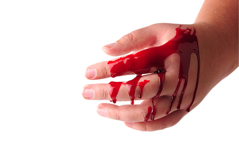Nep bloed uitgesmeerd over een hand met rode druipsporen tussen de vingers, voor een horrorlook