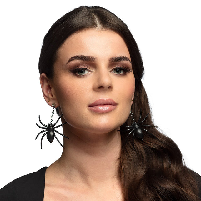 Oorbellen spin zwart gedragen door model, grote spinnen aan kettinkje voor Halloween