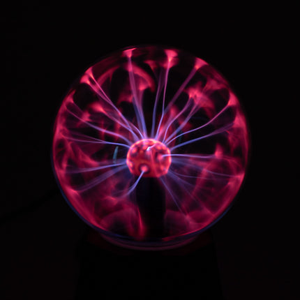Plasmalamp met roze en violette lichtbogen in de glazen bol, oplichtend in het donker