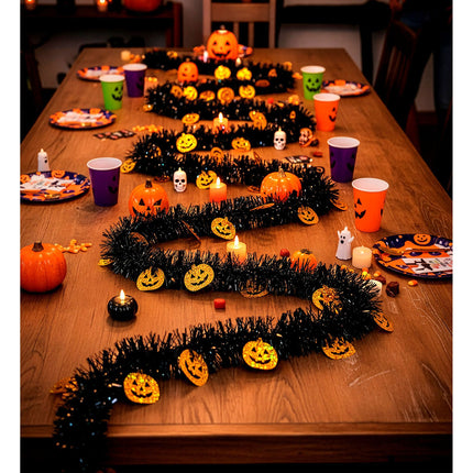 Pompoen slinger als kronkelende tafeldecoratie op een Halloweentafel met kaarsjes
