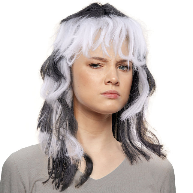 Pruik wit-zwart schouderlang met warrige laagjes en volle witte pony, gedragen op een themafeest