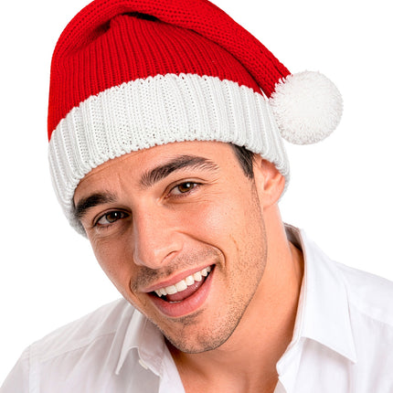 Rode gebreide kerstmuts op heer met pompon opzij langs het hoofd